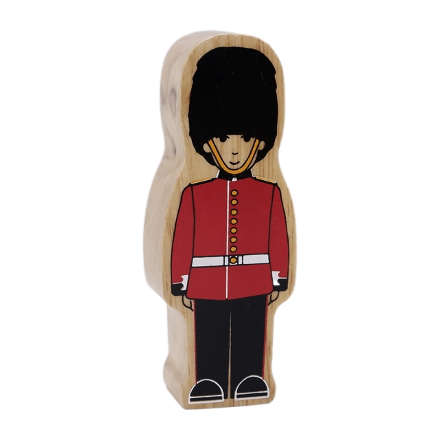 A wooden toy Guardsman wearing red uniform and bearskin
