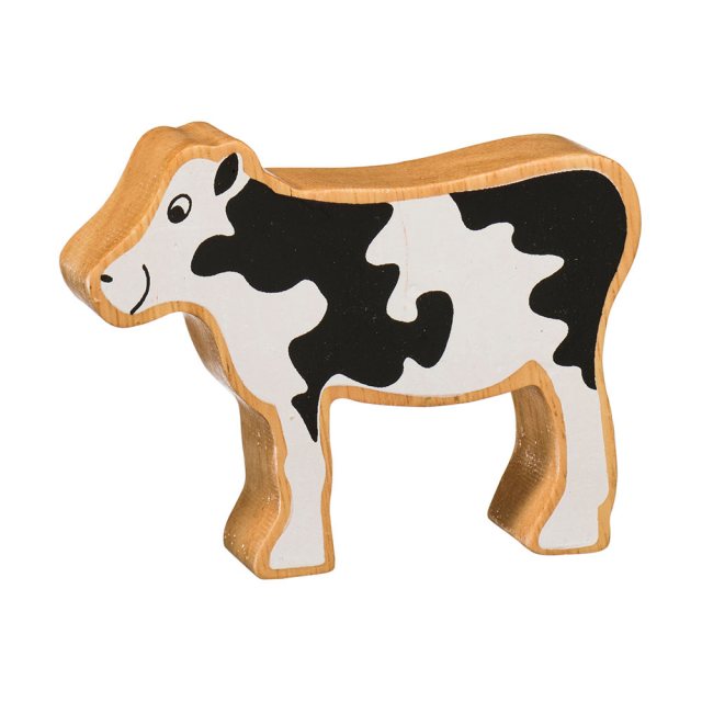 A chunky wooden black and white calf toy figure in profile with a natural wood edge