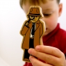 Child playing with toy detective holding the toy up to the camera