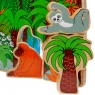A wooden toy sloth balanced on top of wooden toy tropical tree with toy orangutan in the background