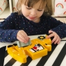 Child playing with a ten piece wooden yellow digger toy jigsaw puzzle