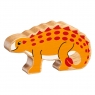 A wooden toy yellow saichania dinosaur in profile with a natural wood grain edge