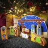 Wooden nativity scene and characters against a wicker backdrop with christmas decorations
