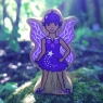 A chunky wooden purple fairy toy figure in profile