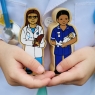 Child holding a midwife and doctor figure from the people who help us playset