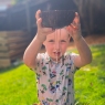 Coconut colander held by child whilst water drains through