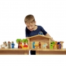 Front view of child playing with wooden toy nativity sat on table top