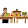 Front view of child playing with wooden toy nativity sat on table top