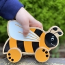 Black and yellow bee push along toy being pushed by childs hand